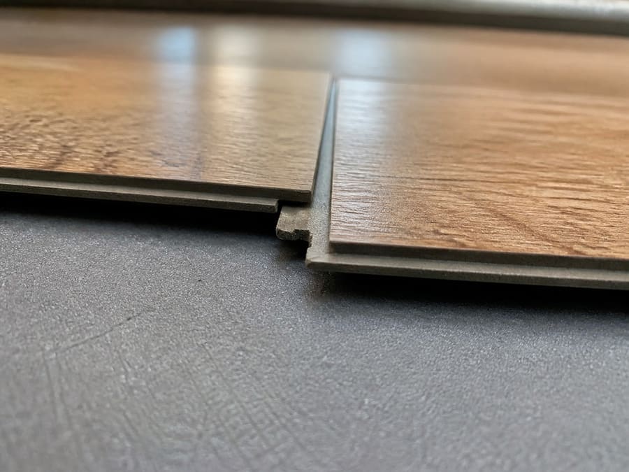 A laminate plank being clicked into place against an already laid row